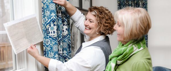 Ladies looking at fabric swatch DR Window