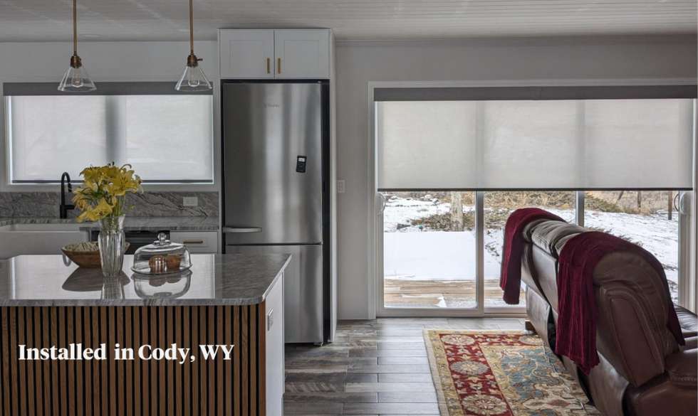 Motorized Solar Shades on window above a sink and a patio door in a Cody home. 